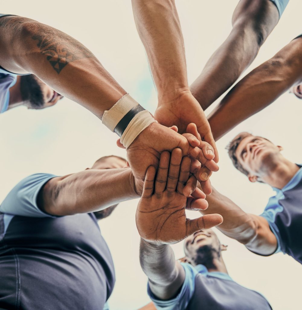 Diversity, team and men with hands together below in sports for support, motivation or goals outdoo.